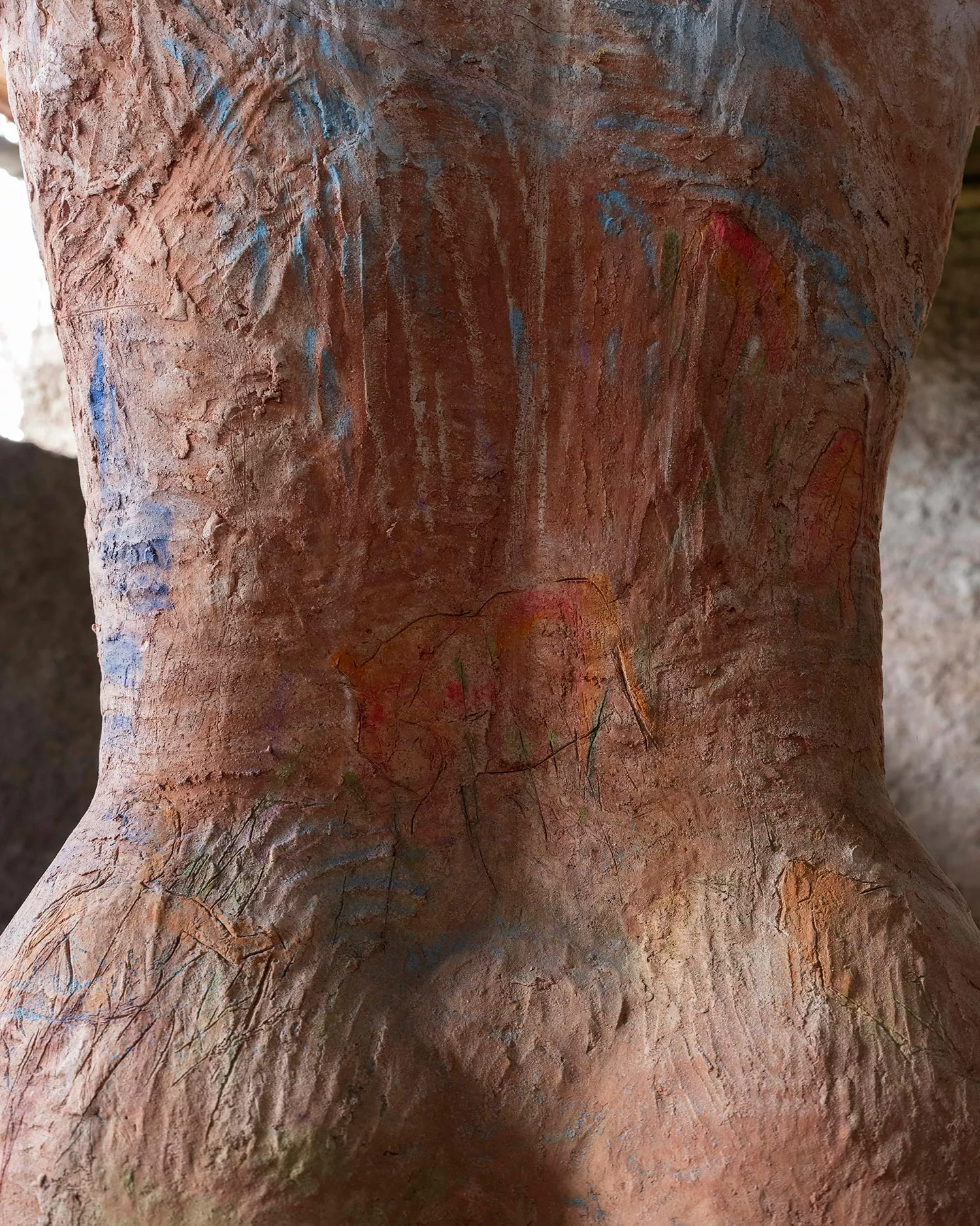 Gaia Fugazza - Gaia Fugazza, Mother of Millions, 2025, detail of the sculpture’s back, with rough engraved lines suggesting human and animal forms and touches of colourful pigment.